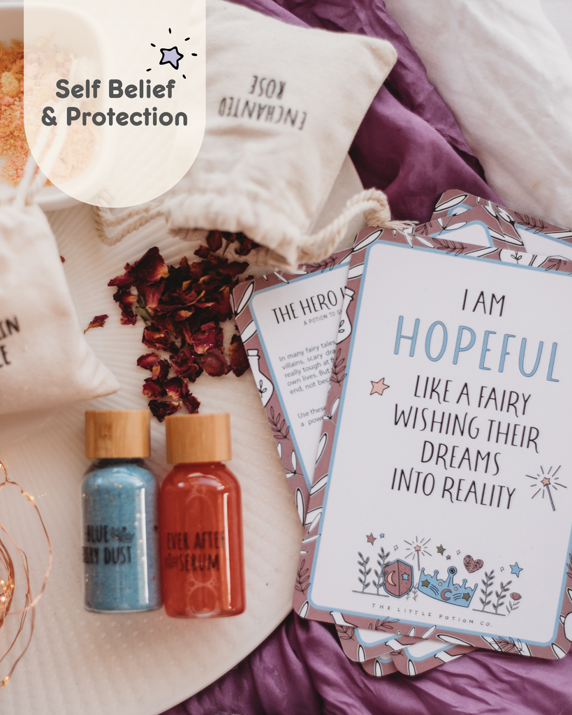 Once upon a potion mindful potion kit. Images displays sparkly liwuid bottles form the potion kit, along with rose petal ingredients and affirmations cards. The affirmation card reads I am hopefully like a fairy wishing their Dreams into reality. 